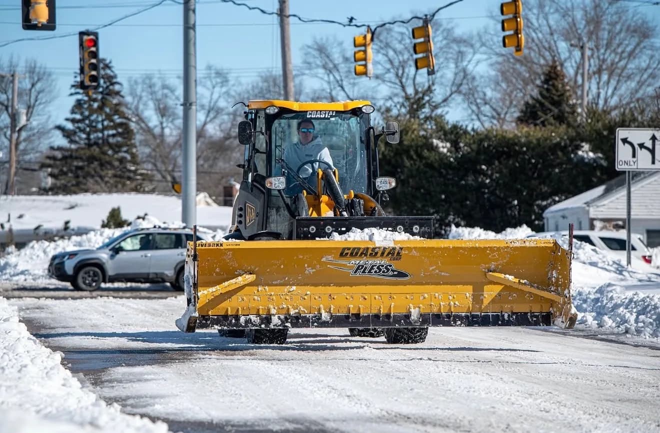 A Coastal Corp plow clears a commercial street at first light after an overnight storm.